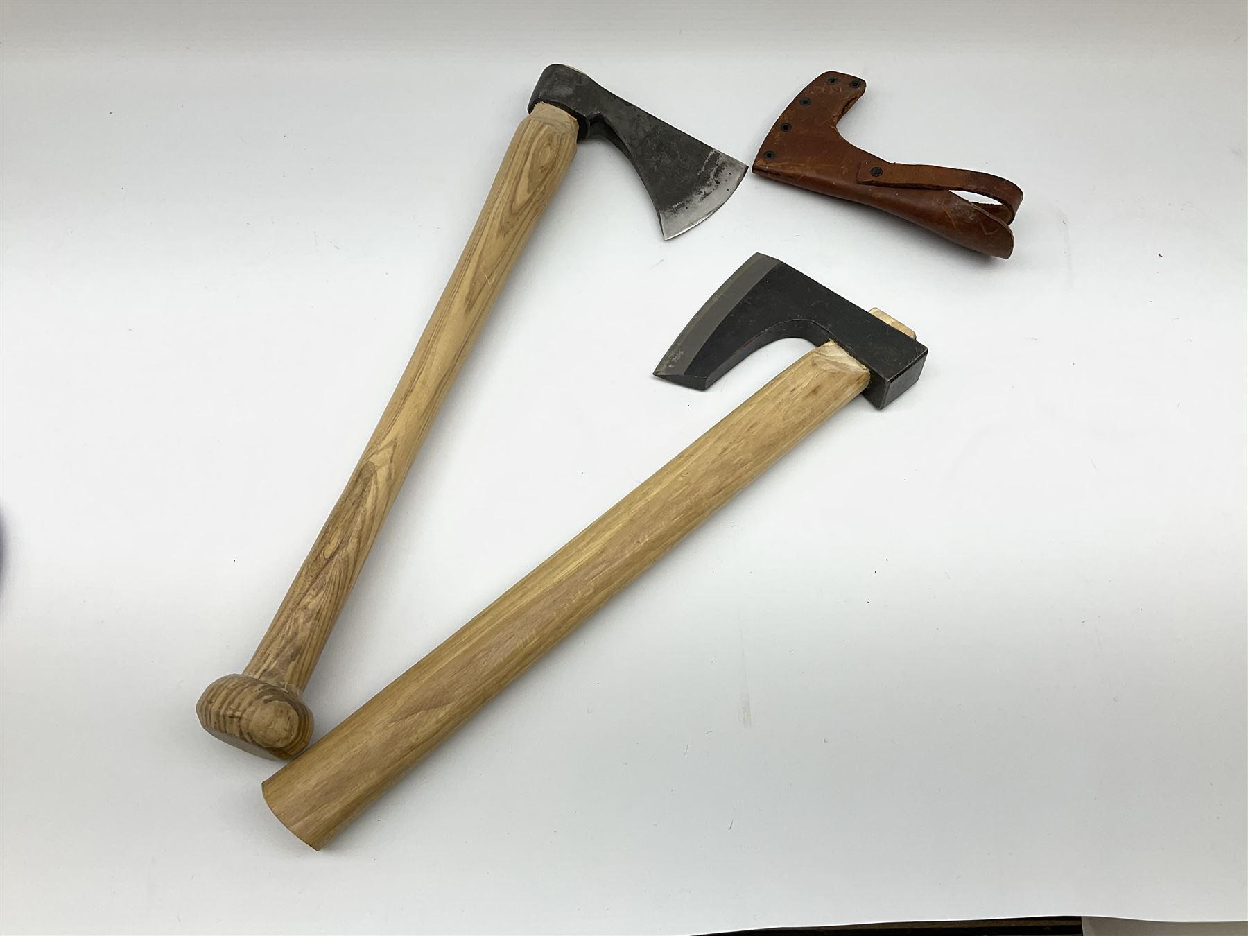 Swedish hunting axe the head marked Gransfors-Bruk, the ash handle with bun pommel and leather head cover, L45cm; and another similar unmarked hunting axe (2)