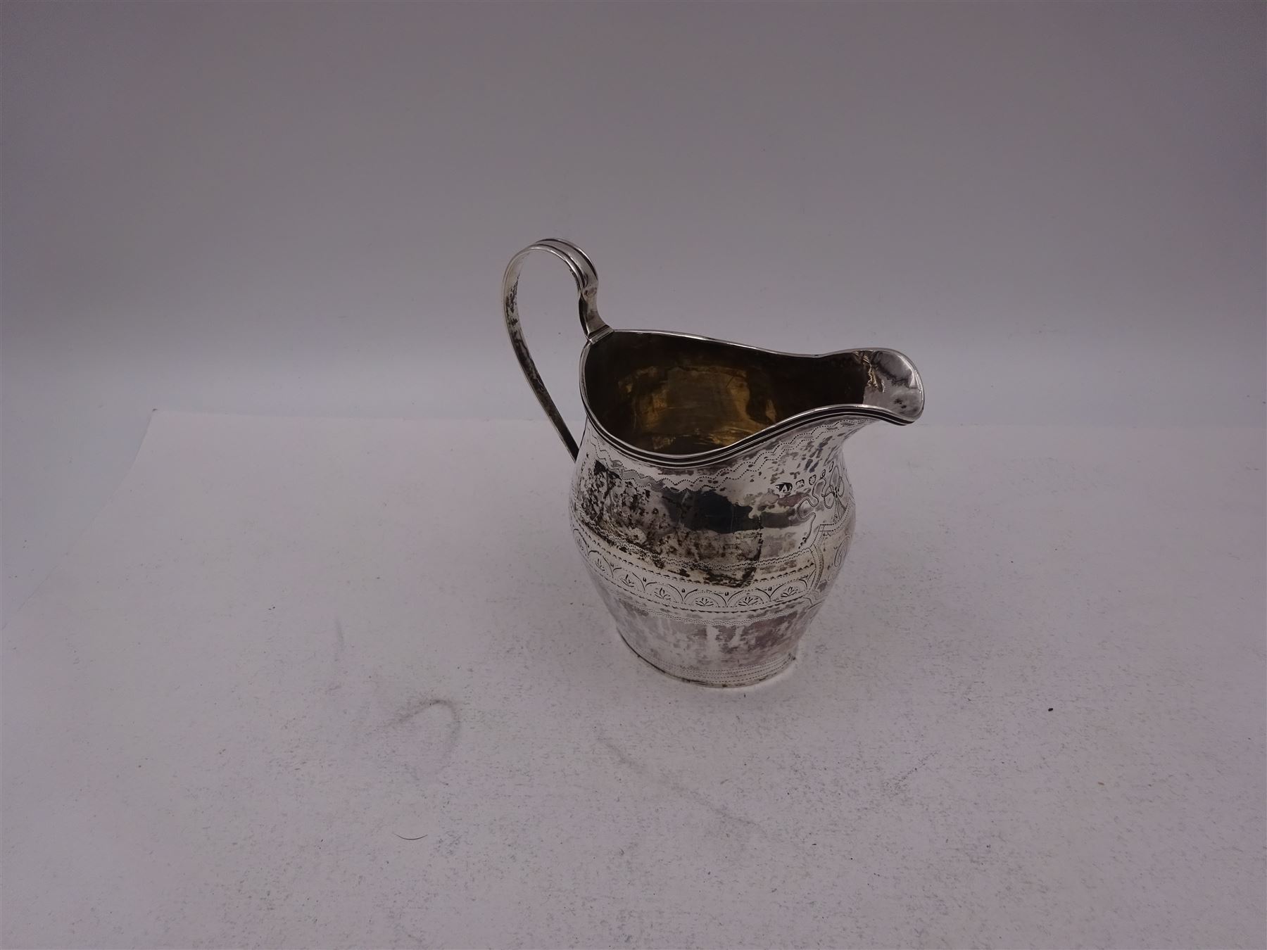 George III silver cream jug, of helmet form, with C scroll handle and a band of engraved strapwork decoration and monogrammed initials to body, hallmarked London 1802, maker's mark SA probably Stephen Adams I, including handle H10.4cm