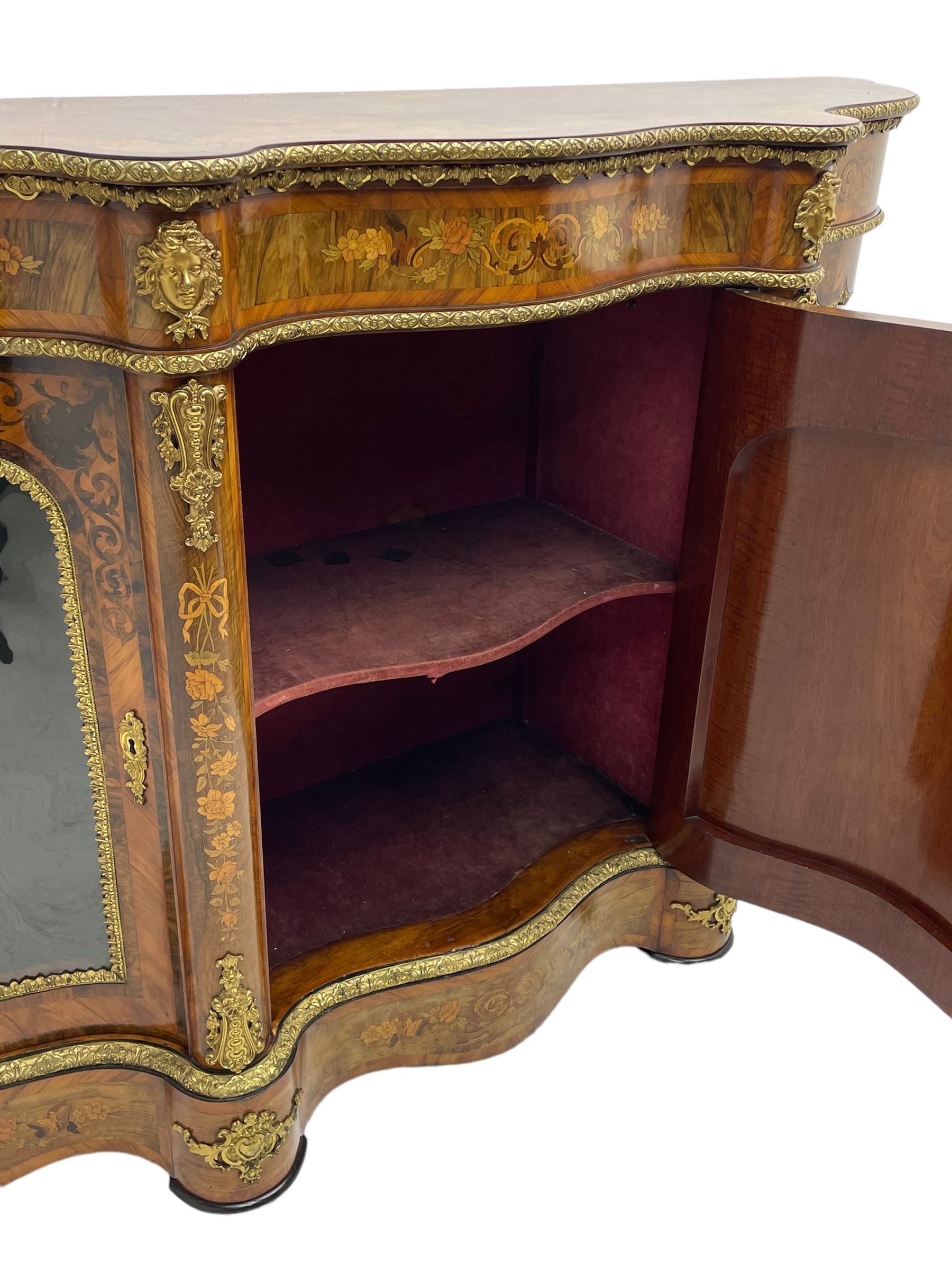 Victorian design inlaid figured walnut credenza sideboard, shaped form with crossbanded and book-matched top, the frieze rails inlaid with foliage scrolls and flower heads, central panelled door inlaid with floral urn flanked by two glazed doors, on shaped plinth base inlaid with foliate decoration, mounted by cast gilt metal masks and floral egg and dart beading 