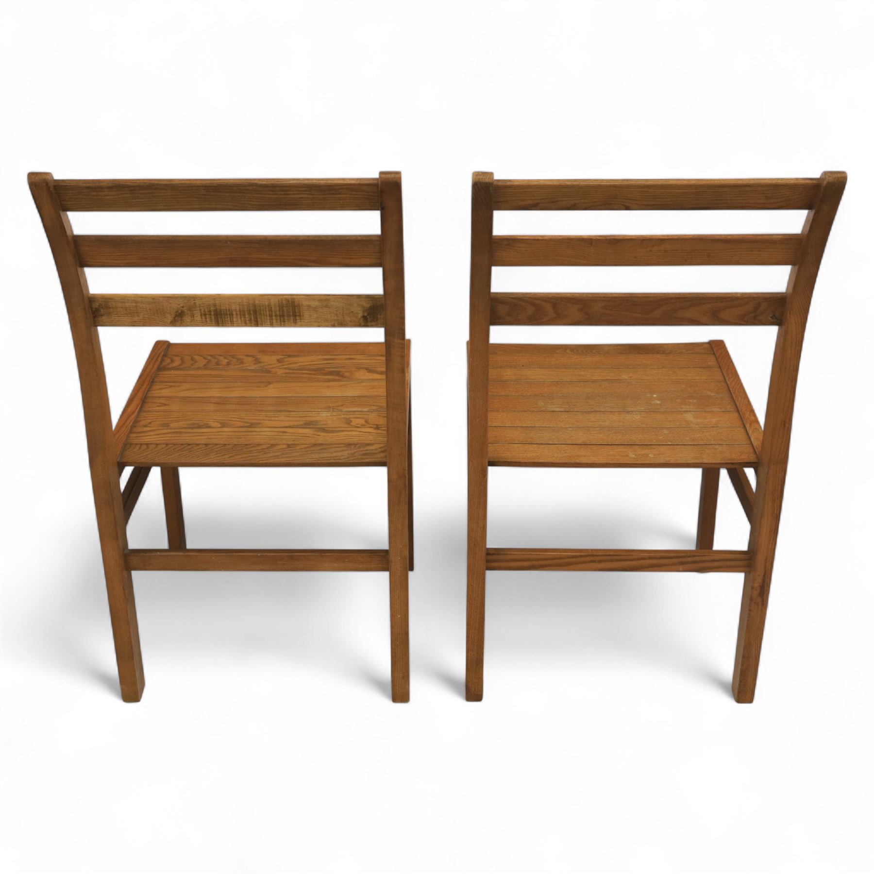 Treske of Thirsk - solid oak refectory dining suite, rectangular top with chamfered edge over trestle base united by a central stretcher, together with six matching slat back dining chairs, including two carvers, with panelled seats and square legs united by stretchers (H 87cm, W 62cm, D 57cm)