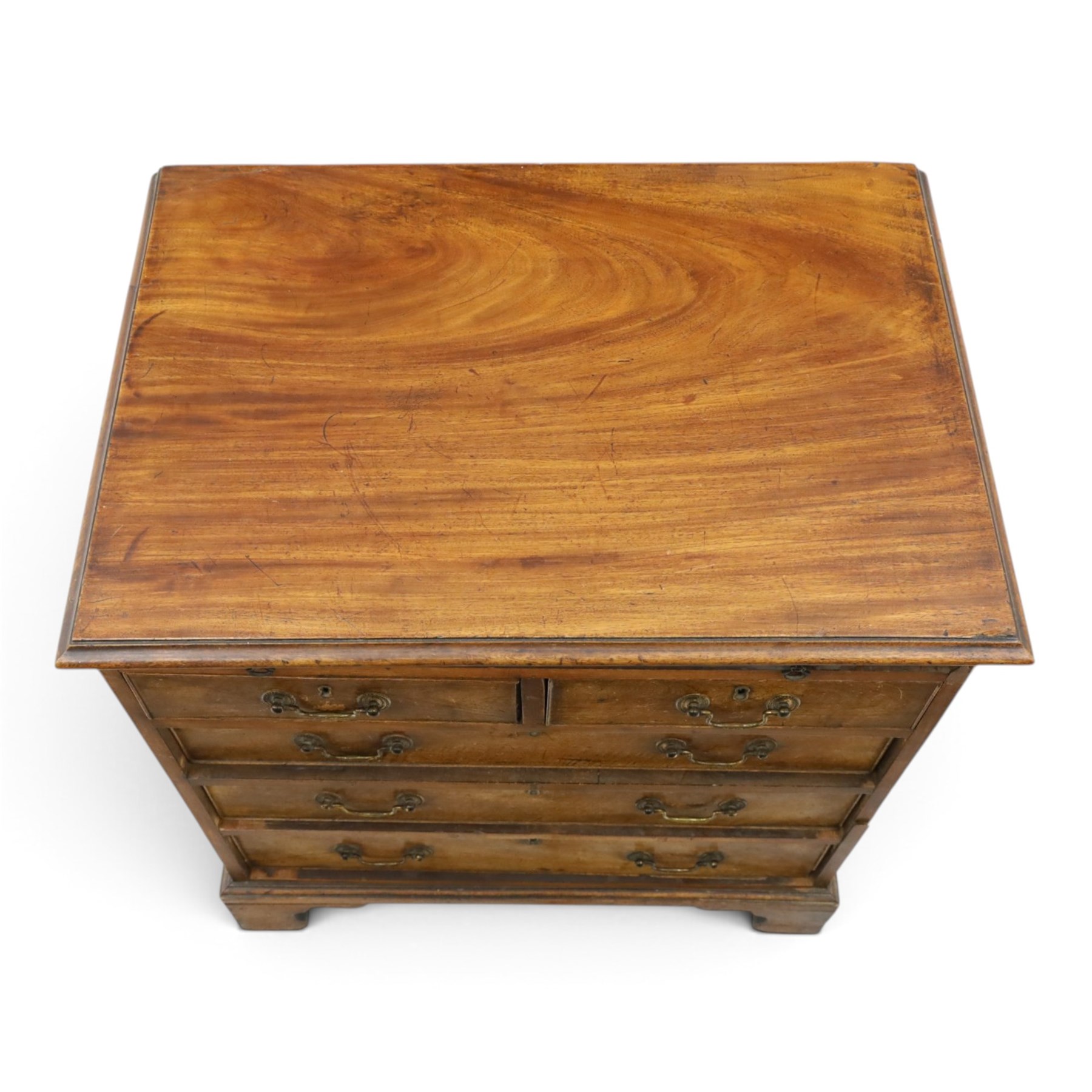 George III mahogany bachelors chest, rectangular top with moulded edge, fitted with brushing slide over two short and three long cock-beaded drawers with brass swan-neck handles, lower moulded edge on bracket feet