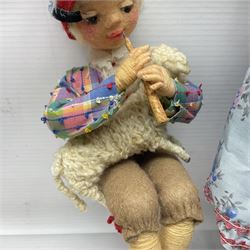 Anna Meszaros Hungary - five hand made needlework figurines including goose girl with stick H20cm; shepherdess in a sitting pose playing a penny whistle with a lamb on her knee; young girl holding a flowerpot; and two others (5)  Auctioneer's Note: Anna Meszaros came to England from her native Hungary in 1959 to marry an English businessman she met while demonstrating her art at the 1958 Brussels Exhibition. Shortly before she left for England she was awarded the title of Folk Artist Master by the Hungarian Government. Anna was a gifted painter of mainly portraits and sculptress before starting to make her figurines which are completely hand made and unique, each with a character and expression of its own. The hands, feet and face are sculptured by layering the material and pulling the features into place with needle and thread. She died in Hull in 1998.