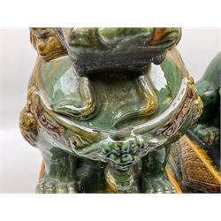 Pair of Chinese Temple Lions or Dogs of Foo, modelled in seated post, one with one front paw resting upon a ball, the other upon a cub, each upon stylised plinth base, H44cm