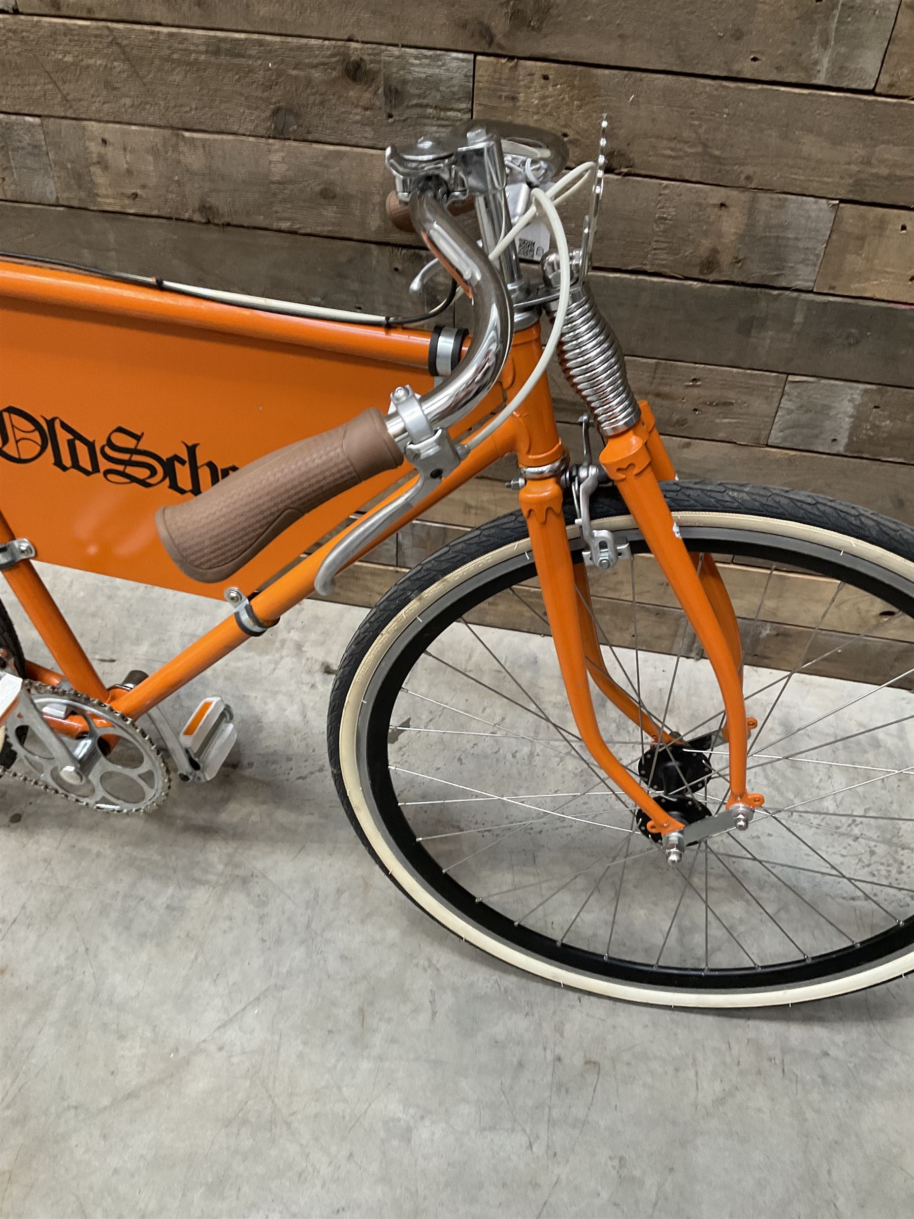 Fully restored vintage advertising bicycle with 2 stroke petrol engine, orange frame, tan leather seat