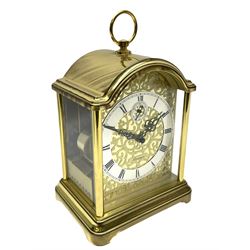 A 20th century brass cased Kieninger (German) chiming mantle clock with a break arch top and three glazed panels, polished sheet brass dial with applied  brass fretwork and a silvered chapter ring, Roman numerals, minute track, steel serpentine hands and seconds dial, three-train spring driven 8-day movement with Westminster, St Michael and Whittington chimes on 8 gong rods, 9 jewel lever platform escapement.  With key. 