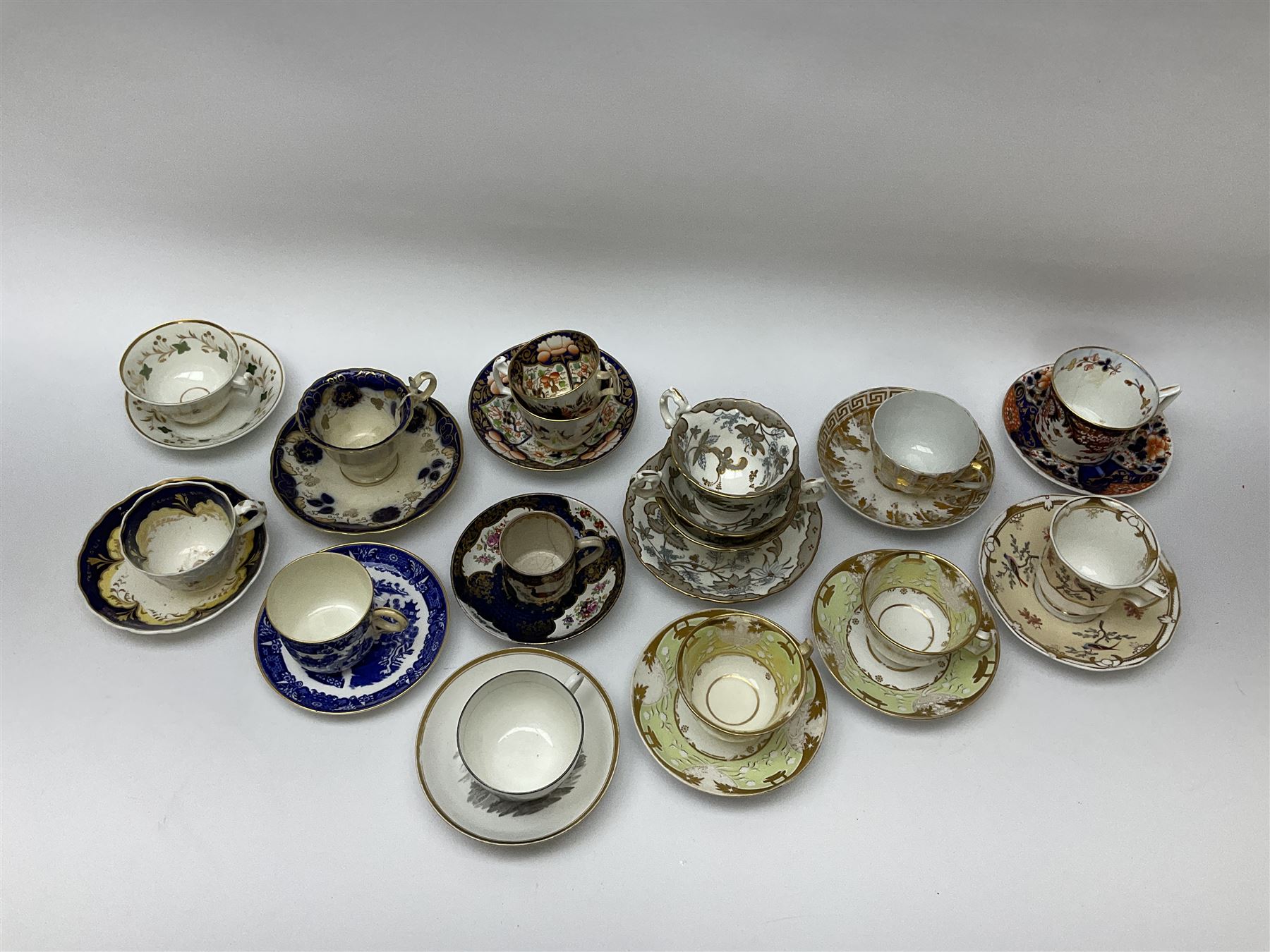 A group of Victorian tea cups and saucers, to include a Derby example decorated in the Imari pallet, a Spode faceted example decorated in gilt with Greek key border and oak leaves, a matched bat printed example, with bute shaped cup, possibly Spode, an example decorated in the Worcester style with reserves of exotic birds and flowers, a Worcester willow pattern example with ring handle cup, etc. 