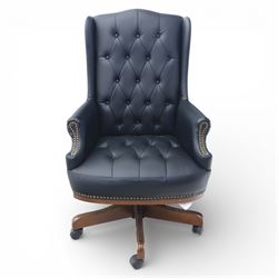 Chesterfield style desk chair upholstered in black, brass studded trim with tall button backed seat, with faux wooden base raised upon castors