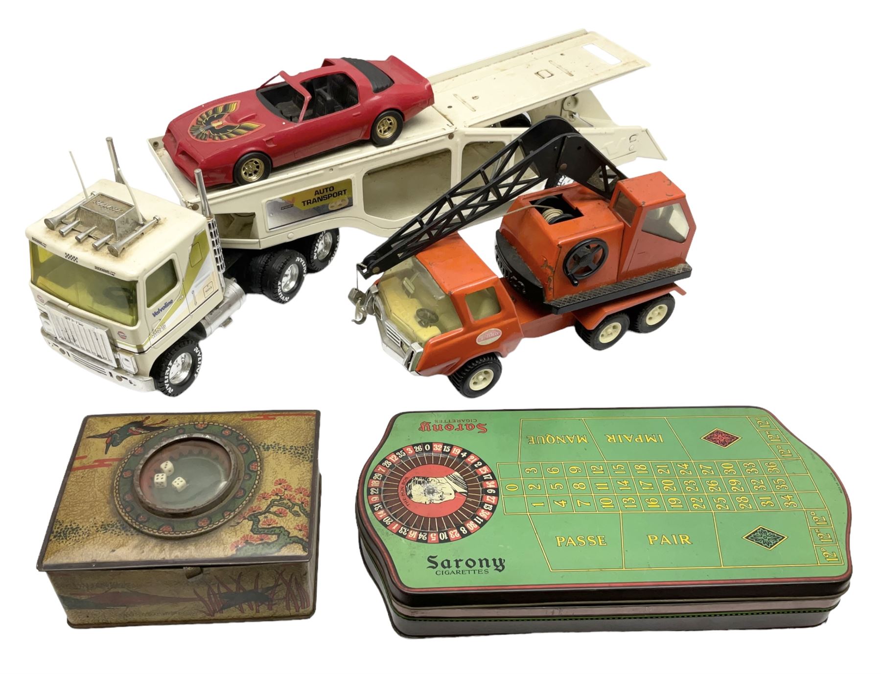 American Nylint large scale tin-plate car transporter L59cm carrying a Testor Toys plastic car; Tonka tin-plate mobile crane; boxed Sarony Cigarettes tin-plate roulette game with rules; and Japanese style tin-plate box, the lid inset with a revolving poker dice game (4)