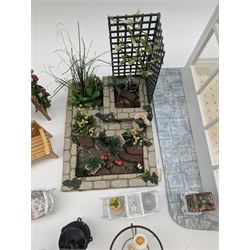 1:12 scale dolls house conservatory and garden accessories, including white wooden glazed conservatory on a stone effect base, black and white metal garden seating, barbecue, plant shelves, parasol, barbeque accessories, large planters, rabbit hutch, animals, chimenea, etc