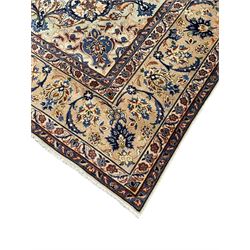 Persian Kashan ivory ground carpet, floral design central medallion surrounded by trailing and interlaced leafy branches with palmettes and flower heads, matching patterned border with guard stripes 
