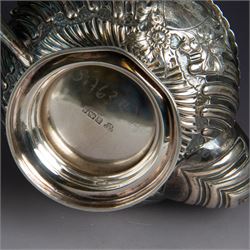 Victorian silver four piece tea service, comprising hot water pot, teapot, milk jug and sugar bowl, of circular part fluted bellied form, with embossed and engraved floral decoration, engraved with initials to body, the teapot and hot water pot with wooden handles and finials, hallmarked Z Barraclough & Sons, Sheffield 1898