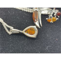 Fifteen silver Baltic amber pendant necklaces, including hedgehog, kingfisher, bee, turtle and dinosaur designs, all stamped 925, on black velvet necklace display stand