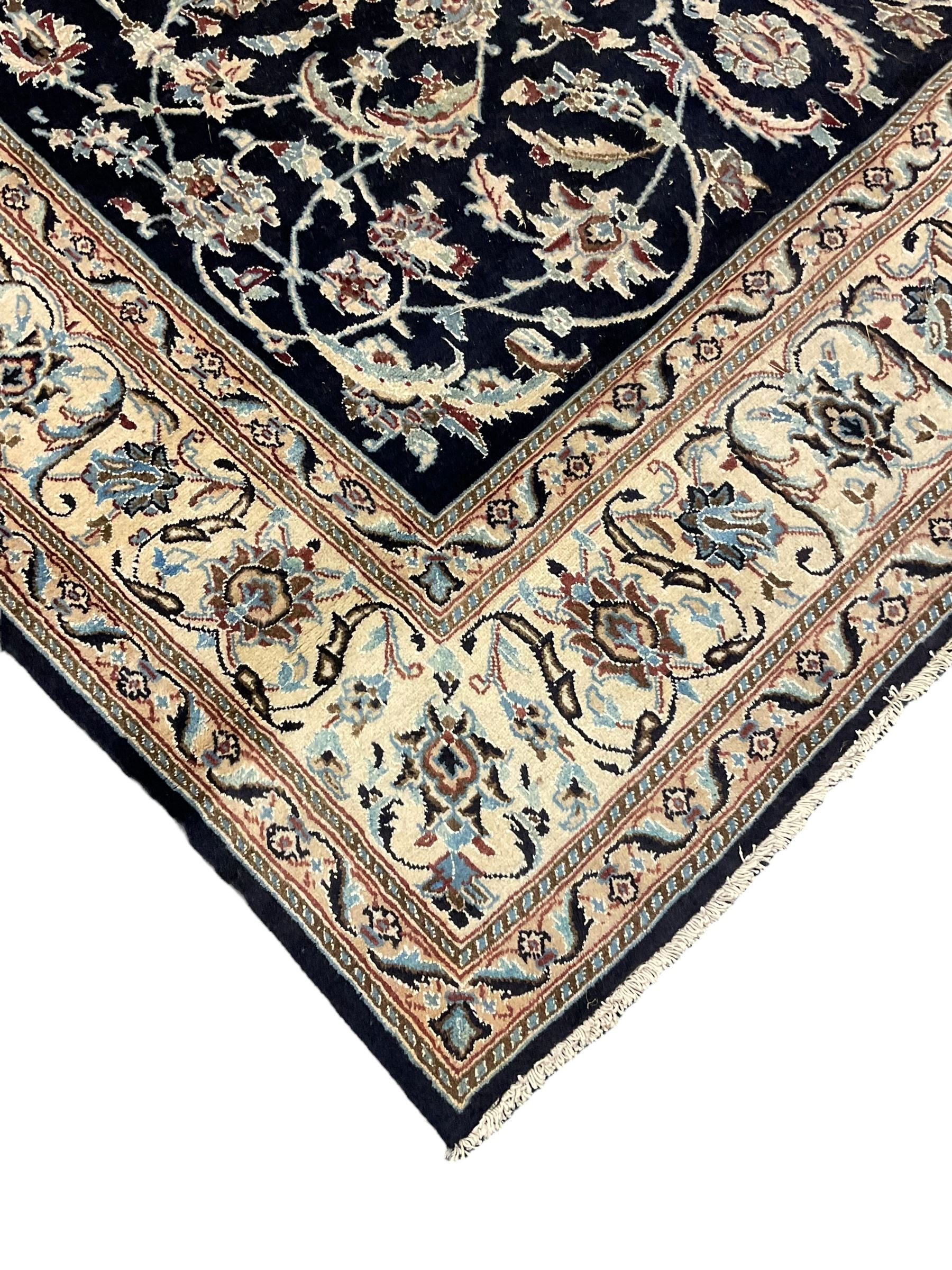 Central Persian part silk indigo ground Nain carpet, the field decorated with interlacing leafy branches and stylised plant motifs, scrolling design border within guard stripes 