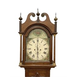 Early 19th century oak cased eight-day longcase clock c1810 - with a swan necked pediment and three matching brass finials, break arch hood door flanked by turned pilasters with brass capitals, trunk with a full length spire topped door on a square plinth with applied skirting, early painted dial with Roman numerals, Arabic five minutes, subsidiary seconds and date dials and steel hands, with floral spandrels and conforming decoration to the arch, dial pinned via a false plate to a rack striking movement, sounding the hours on a bell. With weights pendulum and key.