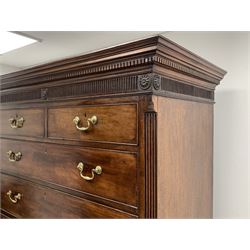 George III Hepplewhite period mahogany chest on chest, projecting dentil cornice over vertical fluted frieze set with stylised roundels, the top section with stop fluted canted corners, two shorts, six long graduating drawers and brushing slide, on shaped bracket feet