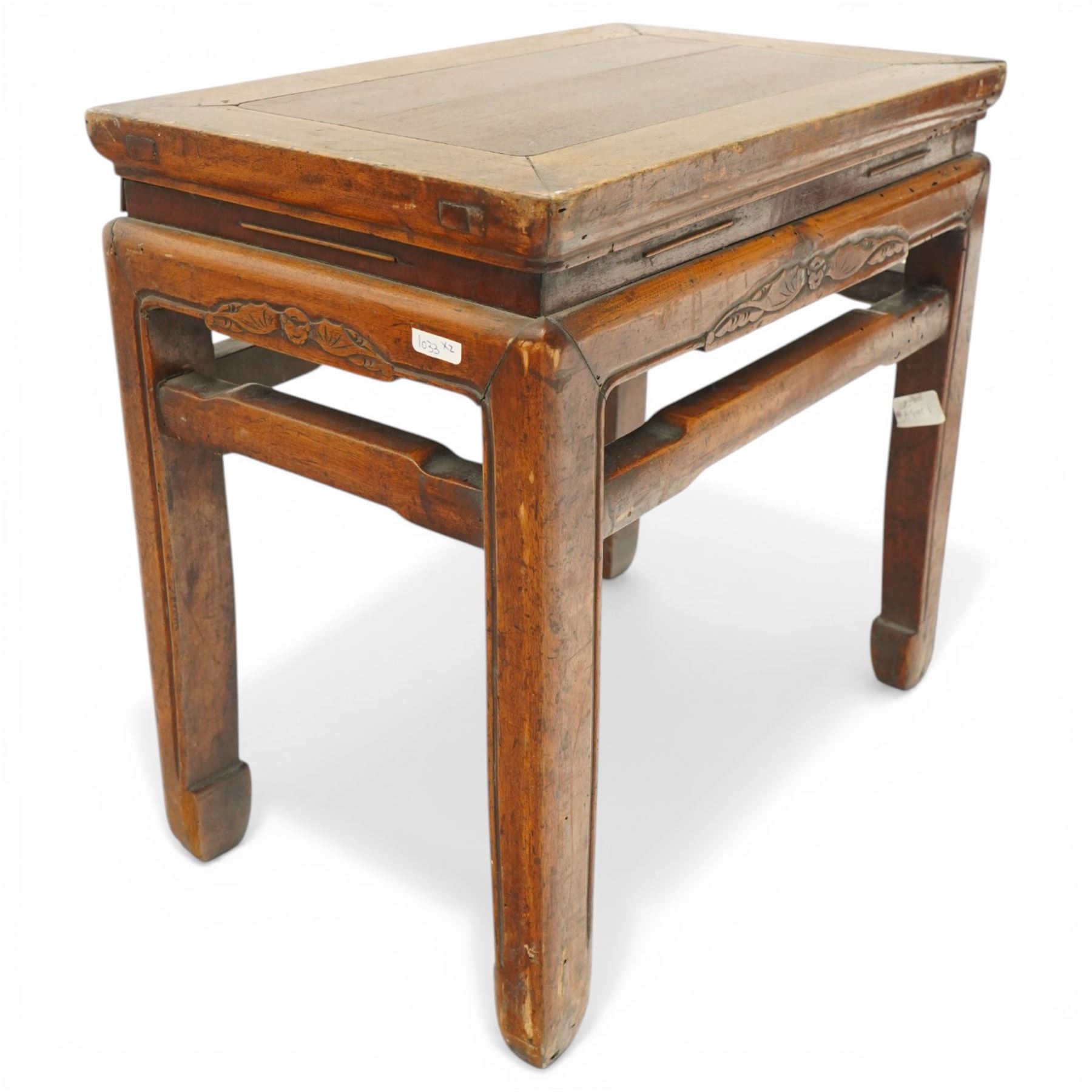 Near pair of 19th century Chinese lacquered elm occasional tables, rectangular top over a bat-motif carved frieze, shaped stretcher rail over tapering supports