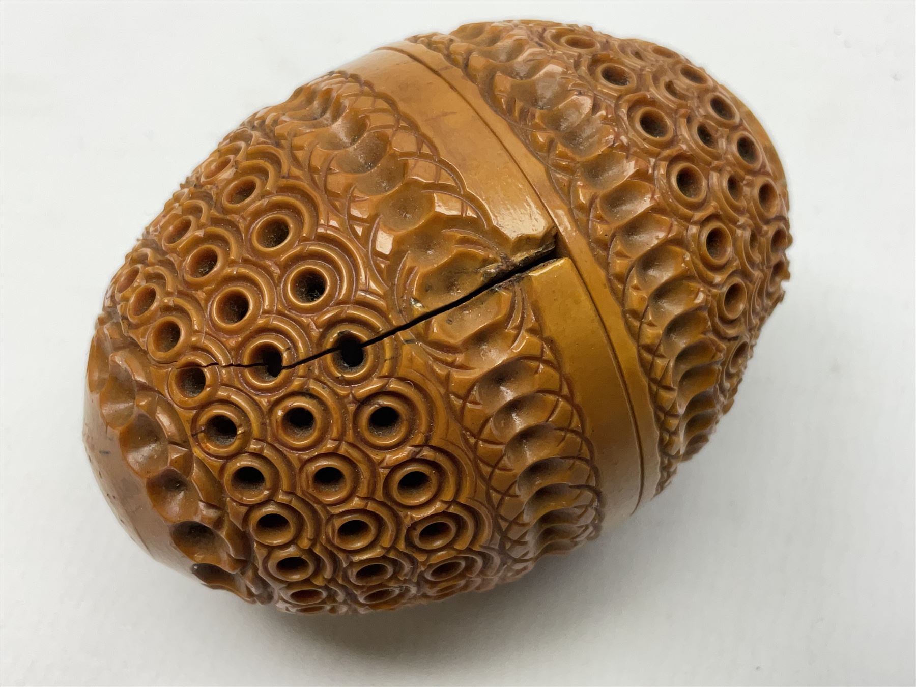 Three 19th century coquilla nut pomanders or flea catchers, each of egg shaped form with carved and pierced decoration and screw threaded join, largest example 6cm
