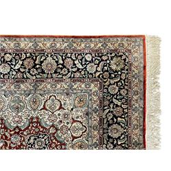 Persian silk finely knotted rug, central floral rosette medallion surrounded by curling branches decorated with palmettes, repeating pattern borders decorated with stylised plants and trailing leafy branches  