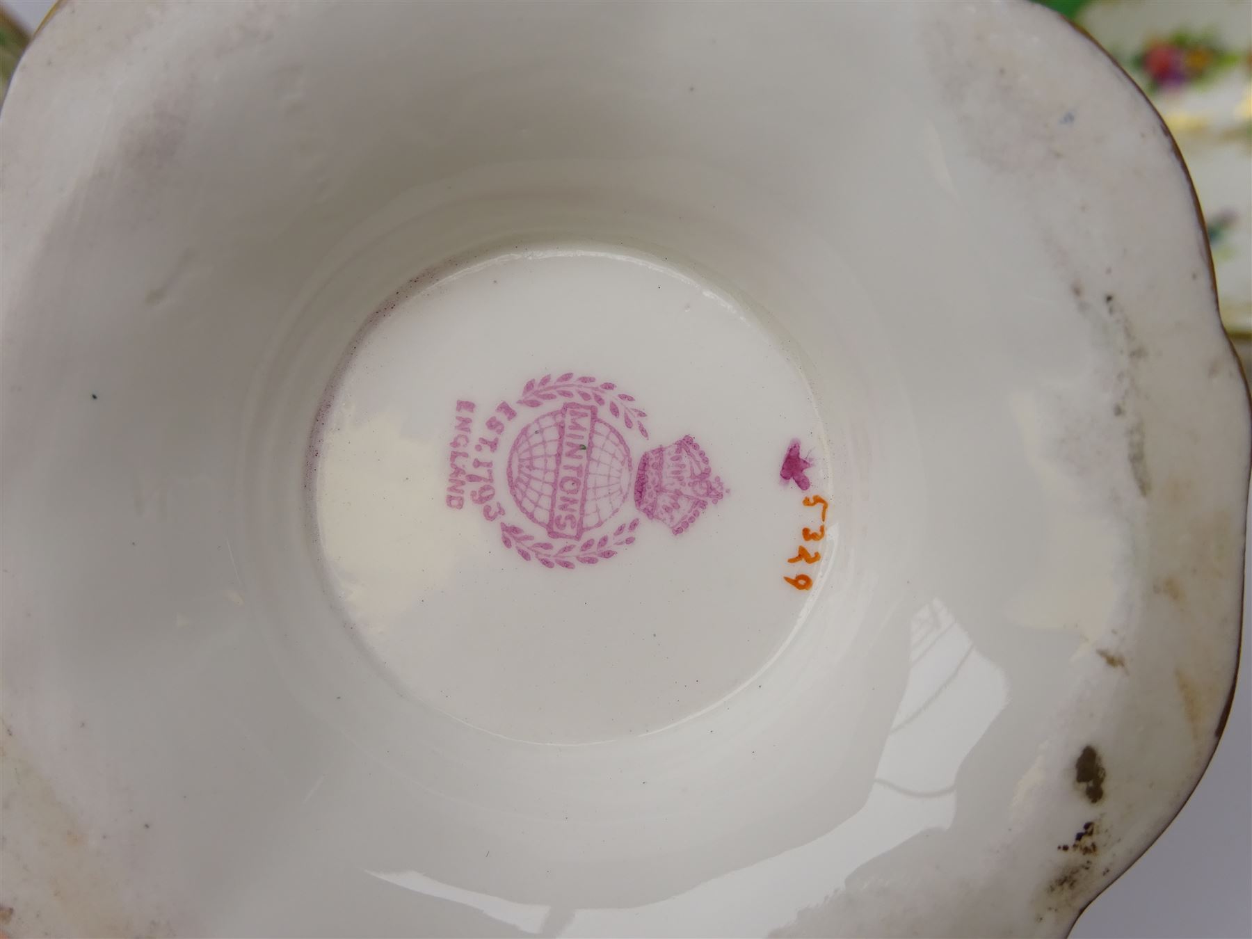 19th century Minton tea set, comprising twelve teacups, eleven saucers, fifteen side plates, cream jug, slop bowl, and two cake plates, decorated with panels of floral sprays, upon a green ground, heightened with gilt throughout, with printed puce mark beneath, and pattern number 5329
