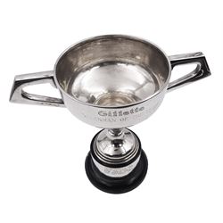 Mid 20th century silver trophy cup, the bowl with twin angular handles and presentation engraving, upon a knopped stem, spreading foot, and black cylindrical plinth, hallmarked Viner's Ltd, Sheffield 1960, trophy cup H15cm overall H20.5cm, approximate gross weight of cup (with screw fixings but not including black base) 10.15 ozt (315.8 grams)