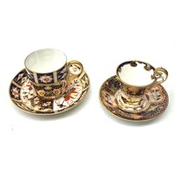 Two Royal Crown Derby Imari pattern tea cups and saucers, the first example with cup of tapering form having high scroll handle, both cup and saucer decorated in the Imari 4591 pattern, with cipher mark for 1920, cup to top of handle H7cm, the second example, both cup and saucer decorated in the Imari 2451 pattern, with cipher mark probably for 1901,  cup H6cm.