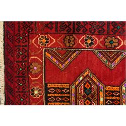 Persian Baluchi crimson ground rug, decorated with three columns of geomtric motifs