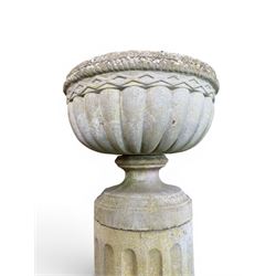 Four 20th century good quality weathered cast stone pedestal urns, circular lobed bowls with rope twist and lattice border, raised on squat base with fluted columns