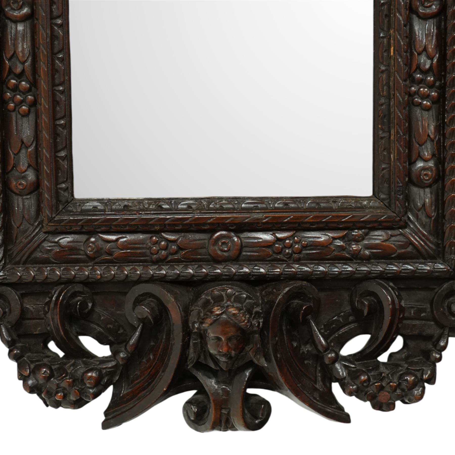 Renaissance-style mid 19th century carved fruitwood wall mirror, carved top surmounted by ‘broken’ arched pediment with central putti figure and grape vine, the sides with two putti figures above C-scroll decorations, and with a similarly carved base
