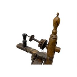 Late 19th century turned beech spinning wheel, upright form with single treadle, triangular base, and a flyer and bobbin assembly surmounted by a turned finial.