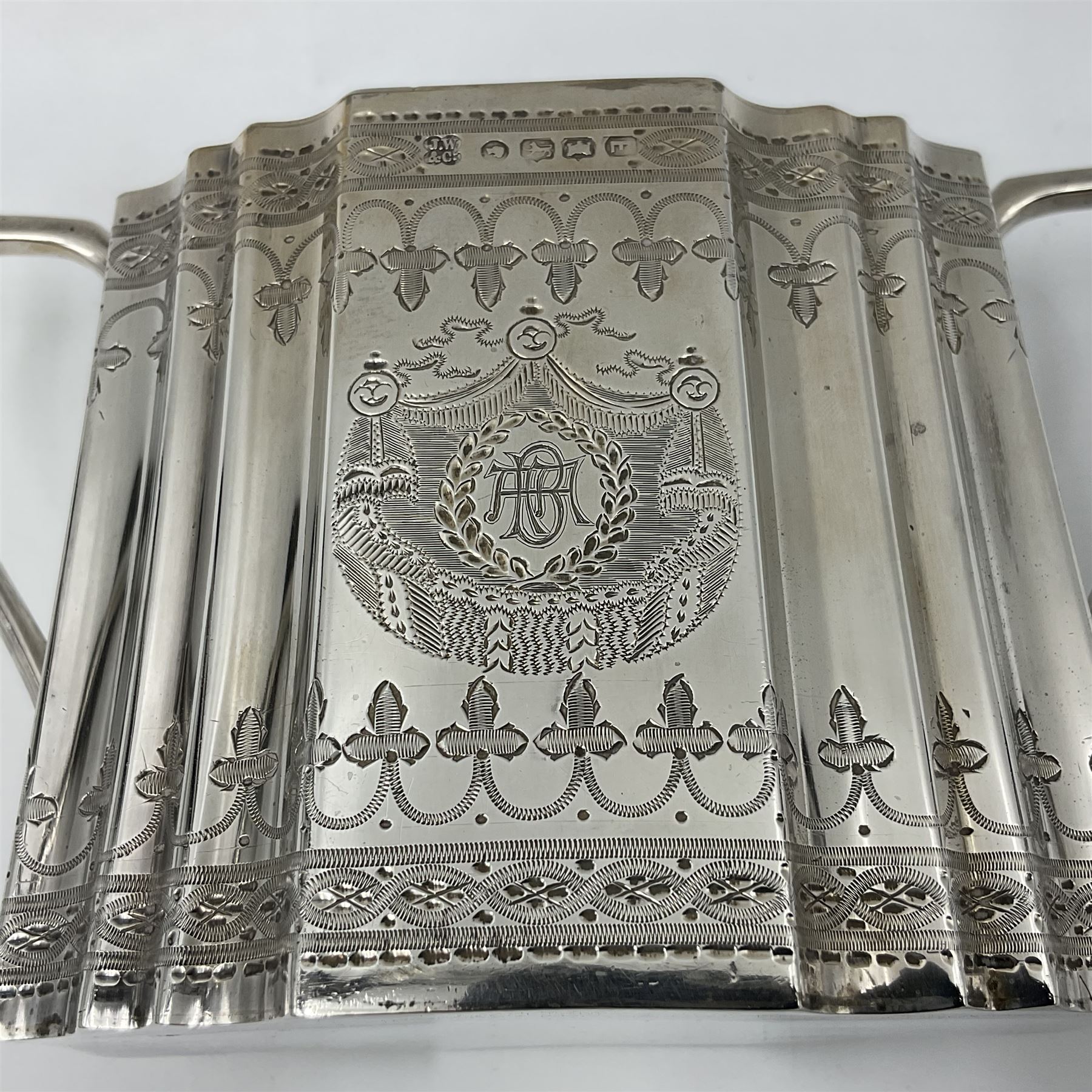 Victorian three-piece silver tea service, comprising teapot, twin handled open sucrier and milk jug, of oval form with shaped rim and C handles, each engraved with crests and bands of strapwork decoration, the milk jug and sucrier with gilt interiors, hallmarked Josiah Williams & Co, Exeter 1881, the teapot with ivory insulators and finial, all contained with a tooled leather, blue silk and velvet lined fitted case, retailed by West & Sun, Dublin 
This item has been registered for sale under Section 10 of the APHA Ivory Act