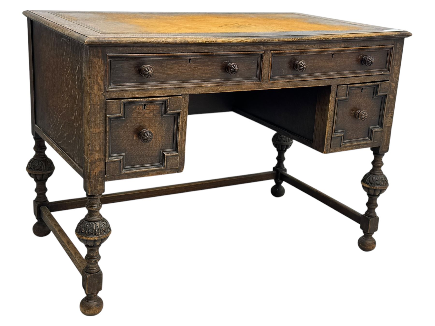 Early 20th century Jacobean design oak desk, with rectangular top inset with worn tooled leather, two frieze drawers over pedestals each fitted with a pair of panelled drawers, turned handles, on carved and fluted tapering legs united by stretchers 