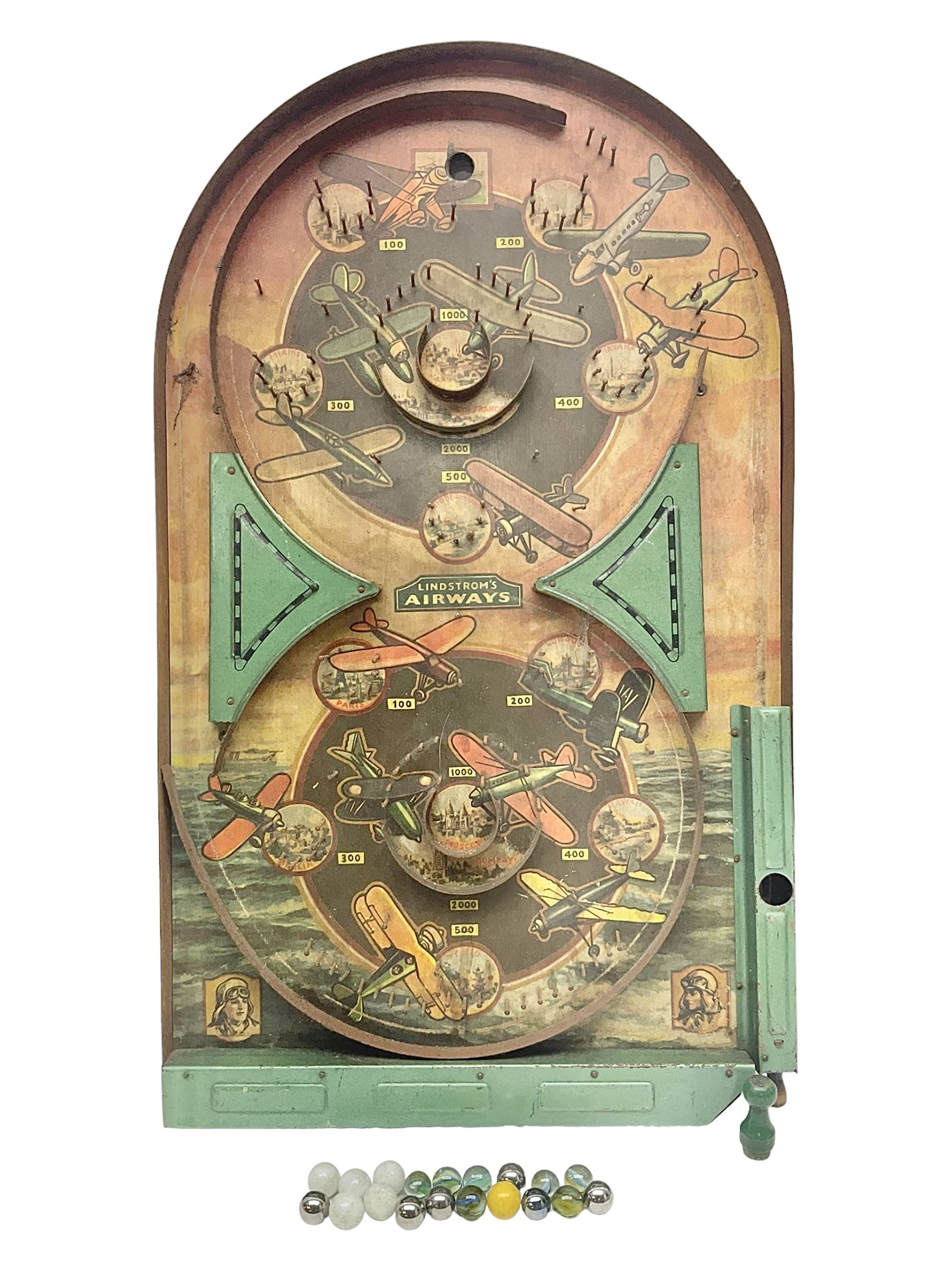 1934 Lindstrom's 'Airways' tin-plate bagatelle game by Lindstrom Tool and Toy Company Bridgeport Conn., the decorative bagatelle board depicting Lindstrom's epic airway routes; with wooden peg and quantity of balls H61cm