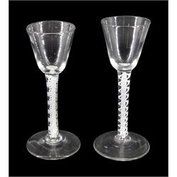 Two 18th century drinking glasses, the funnel bowls upon double series opaque twist stems and conical feet, tallest H14.5cm