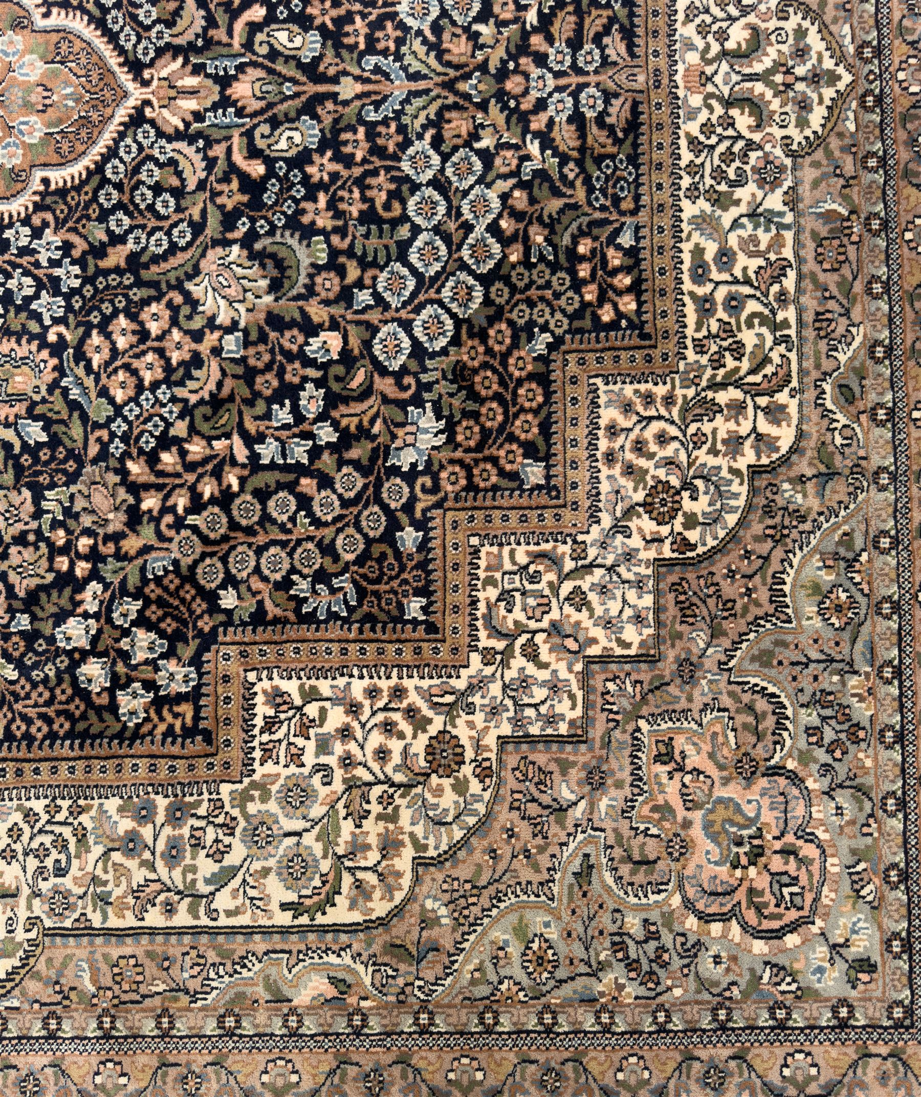 Large Persian indigo ground rug, the busy field decorated with trailing branches and flower heads, peach border decorated with palmettes -