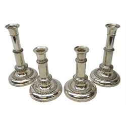  Set of four early 20th century silver-plated telescopic table candlesticks, shaped sconces on plain columns and stepped circular bases with gadrooned detail, stamped 252, H20.5cm max (4)  
