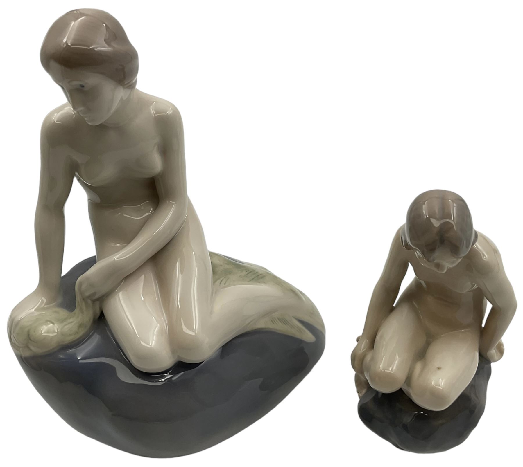 Two Royal Copenhagen figures, comprising The Little Mermaid, modelled by Edvard Eriksen, no. 4431 and Royal Copenhagen girl on stone no 4027, Little Mermaid H22cm