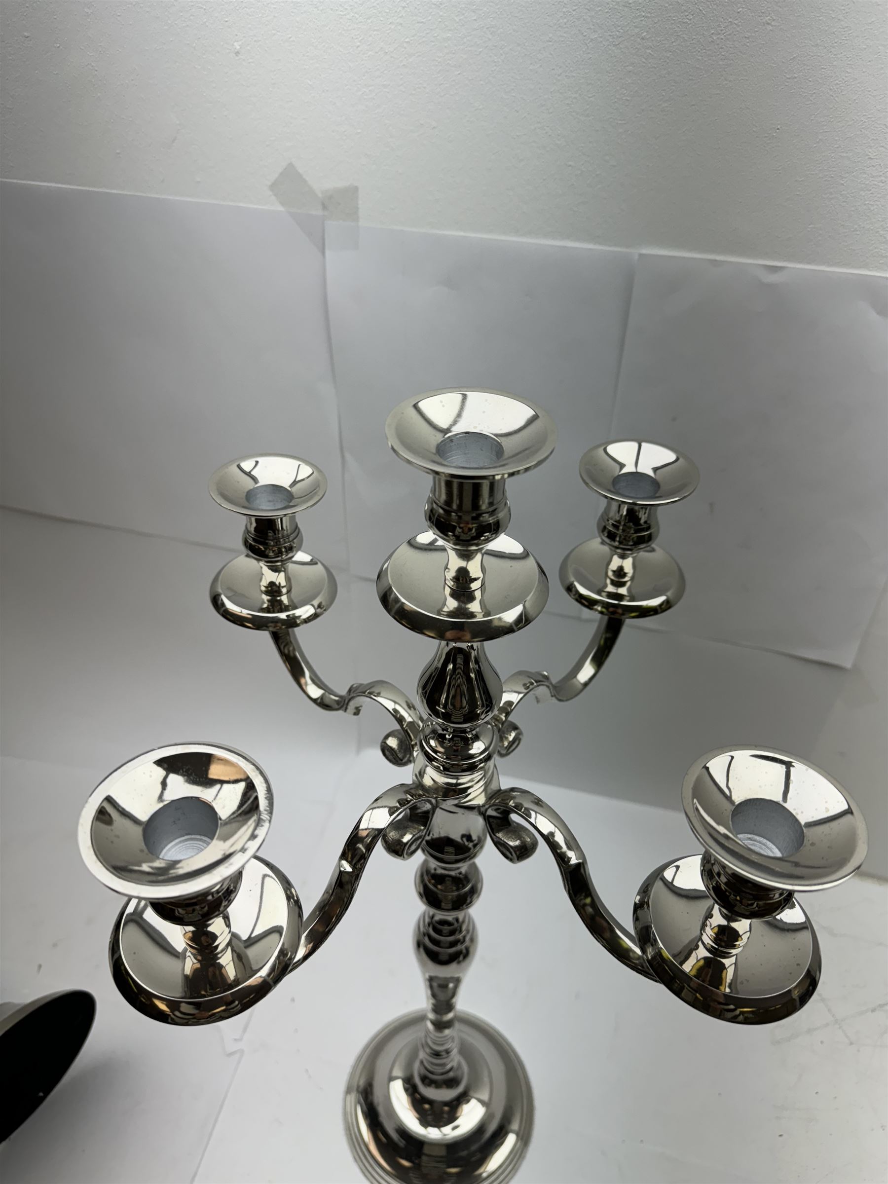 Pair of four branch candelabras, urn-shaped nozzles raised upon scroll branches supported from tapering central stem, with a stepped circular base, H59cm