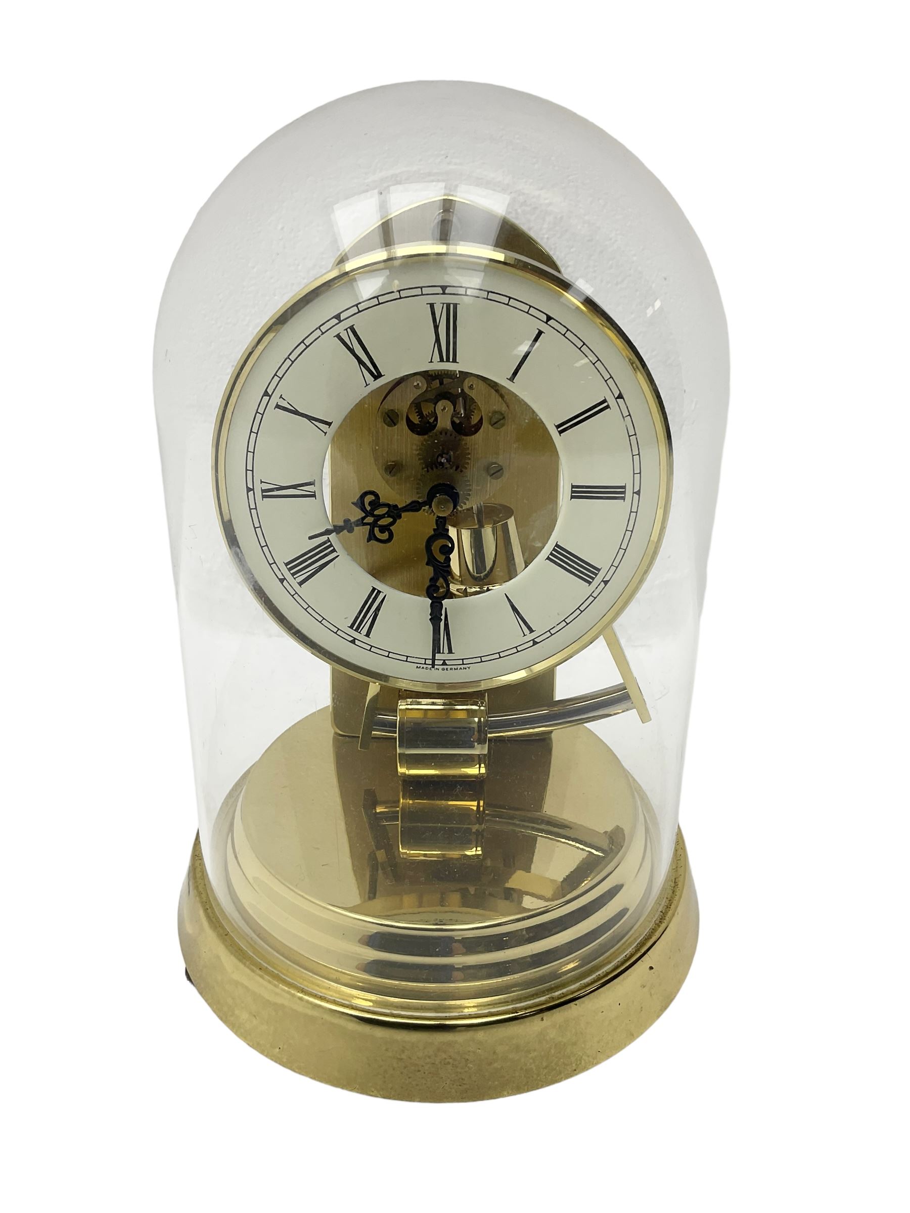  A late 20th century -  German Kieninger & Obergfell, “Kundo” battery operated
mantle clock under an acrylic shade, with an electrically operated solenoid pendulum housed on a circular brass base, skeleton movement with visible motion work through a painted 4-1/2” open chapter ring, with pierced steel hands, Roman numerals and minute track.