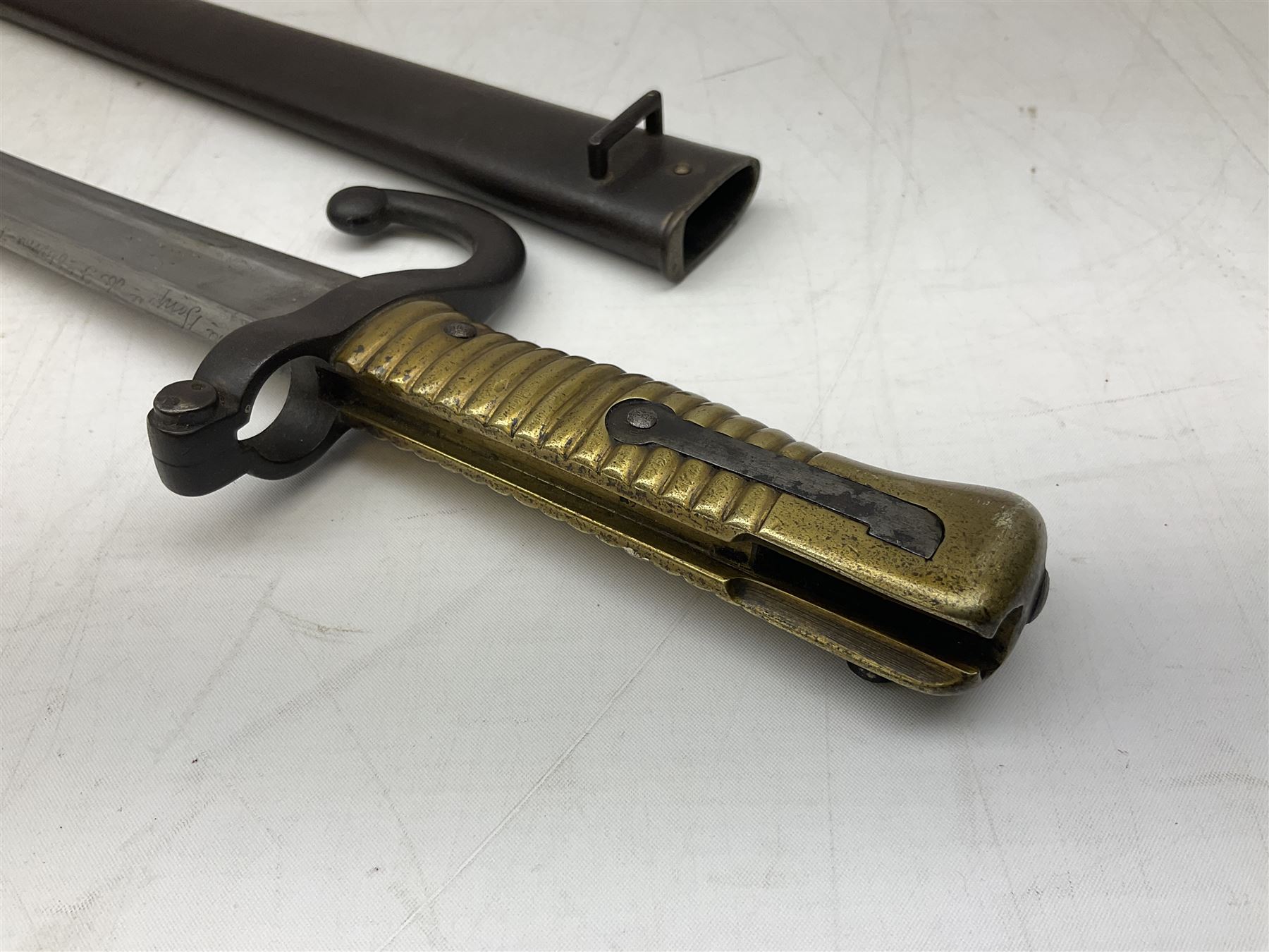 French model 1866 sabre bayonet, the 57.5cm curving blade marked St. Etienne 1868; in associated steel scabbard L71cm overall