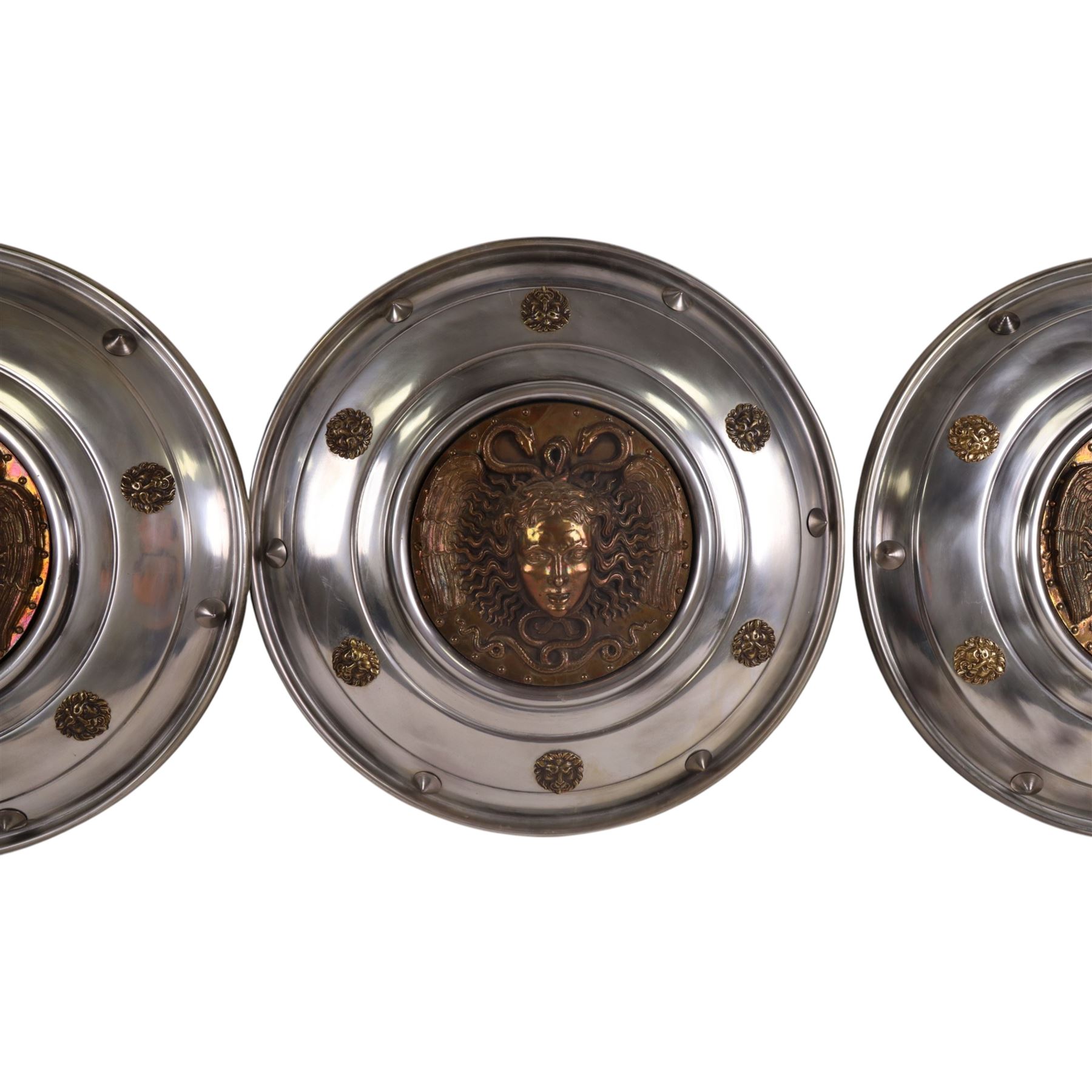Three wall hanging shields the central panel decorated in relief with Medusa, D56cm 