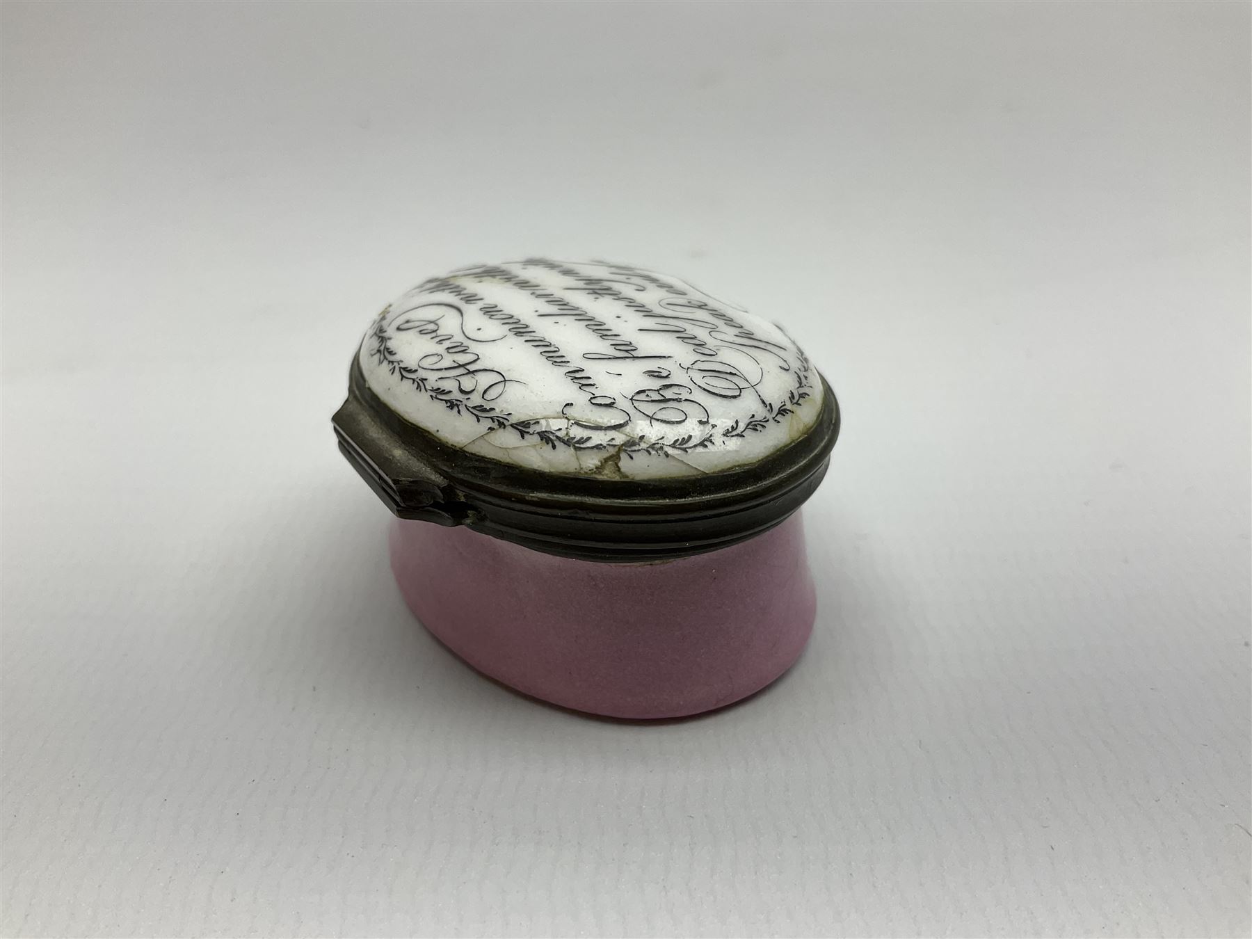 Late 18th century Staffordshire enamel patch box, of oval form with pink base, the hinged cover inscribed 'Have Communion with few, Be familiar with One, Deal justly with All, Speak evil of none' upon a white ground, opening to reveal mirror beneath, W4cm