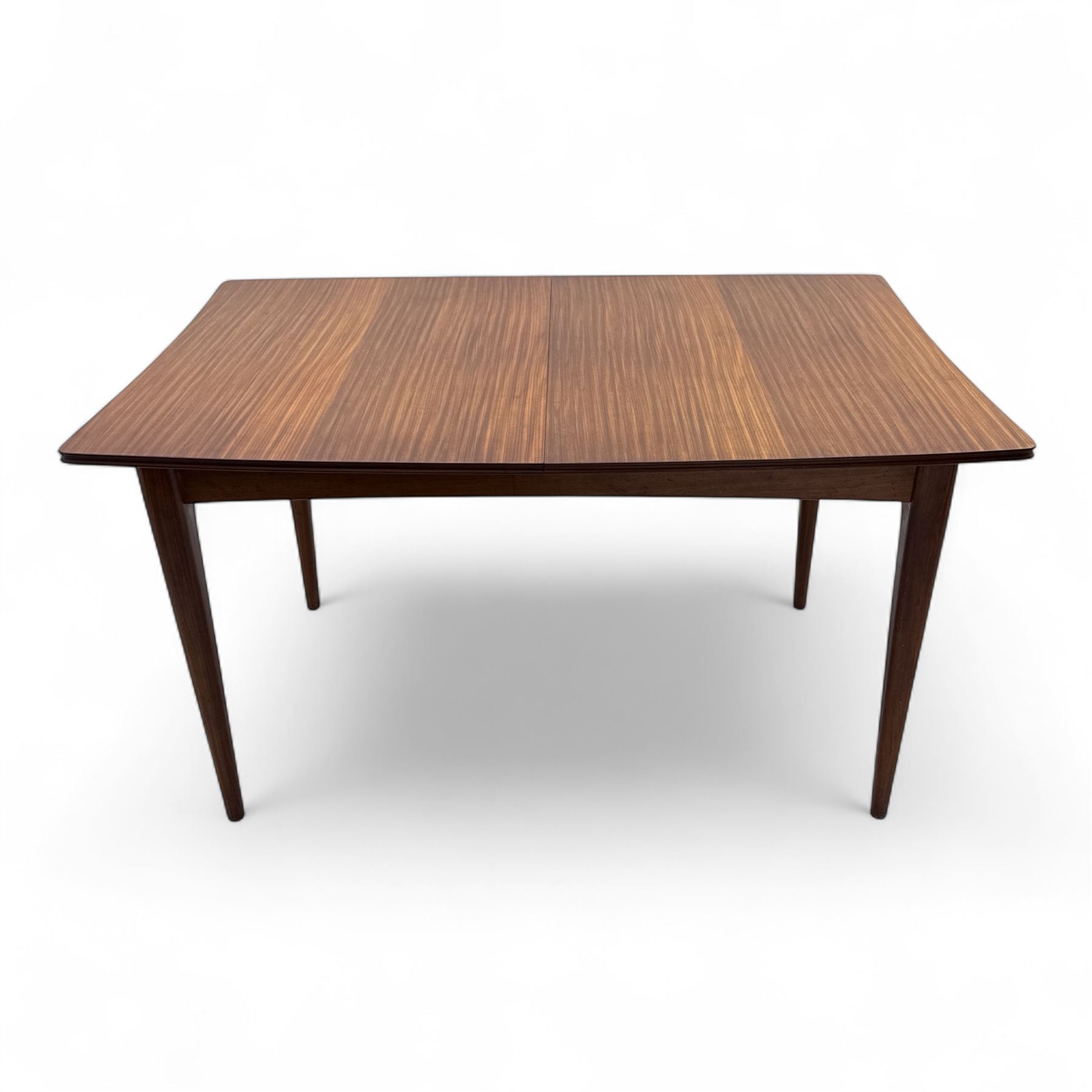 Richard Hornby for Fyne Ladye - mid-20th century afromosia teak dining table, tapered rectangular top with fluted edge and recess for spare leaf, raised on slender legs, teak framed chairs, of ladder back design, with drop-in seat, upholstered seat, with tapered front legs and slightly raked rear legs, retailed by Heals of London, table extended width 181cm depth 86cm height 74cm - chairs width 48cm depth 41cm height 87cm 