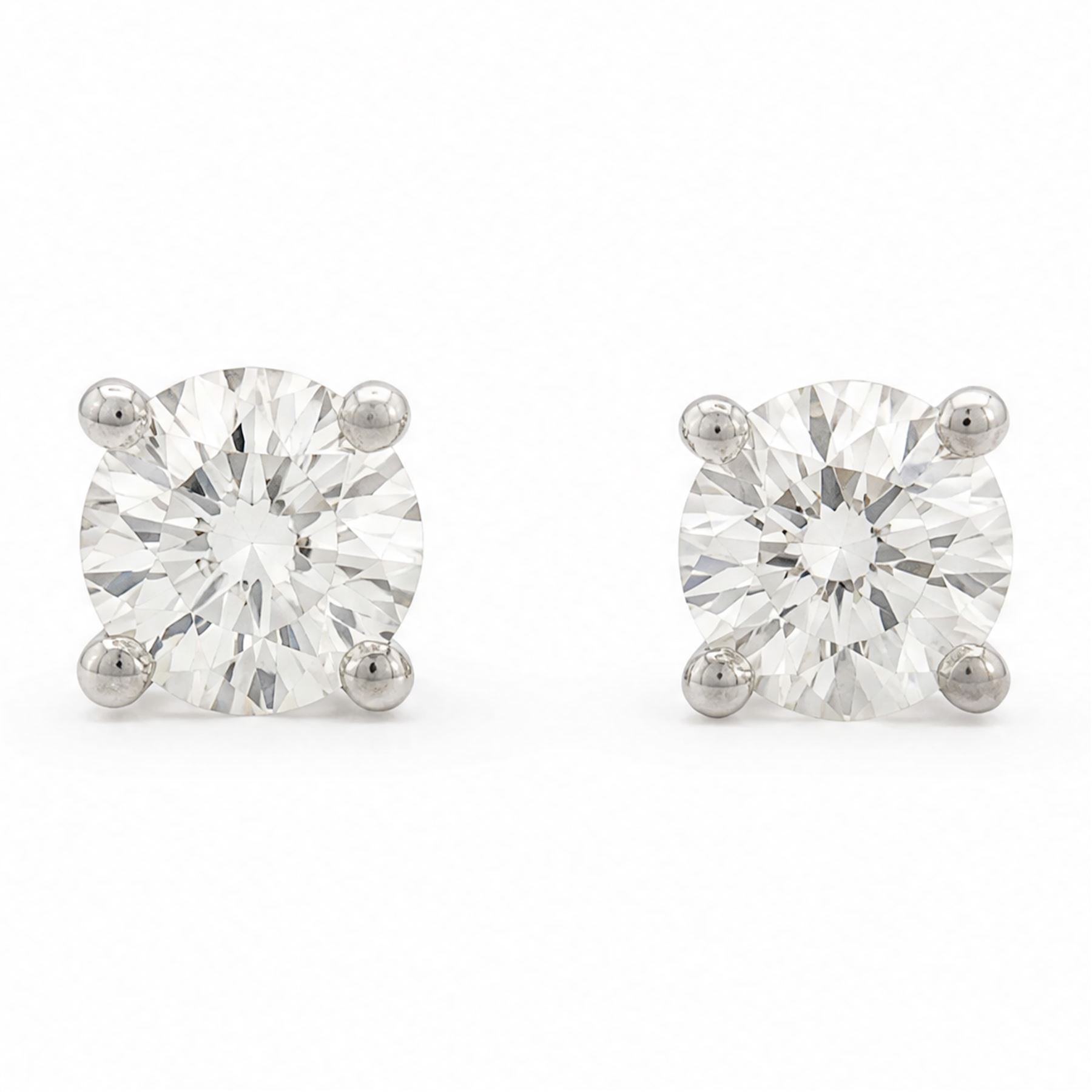 Pair of platinum diamond earrings, each stud four claw set with a single round brilliant cut diamond, stamped Pt 950, total diamond weight approx 0.85 carat