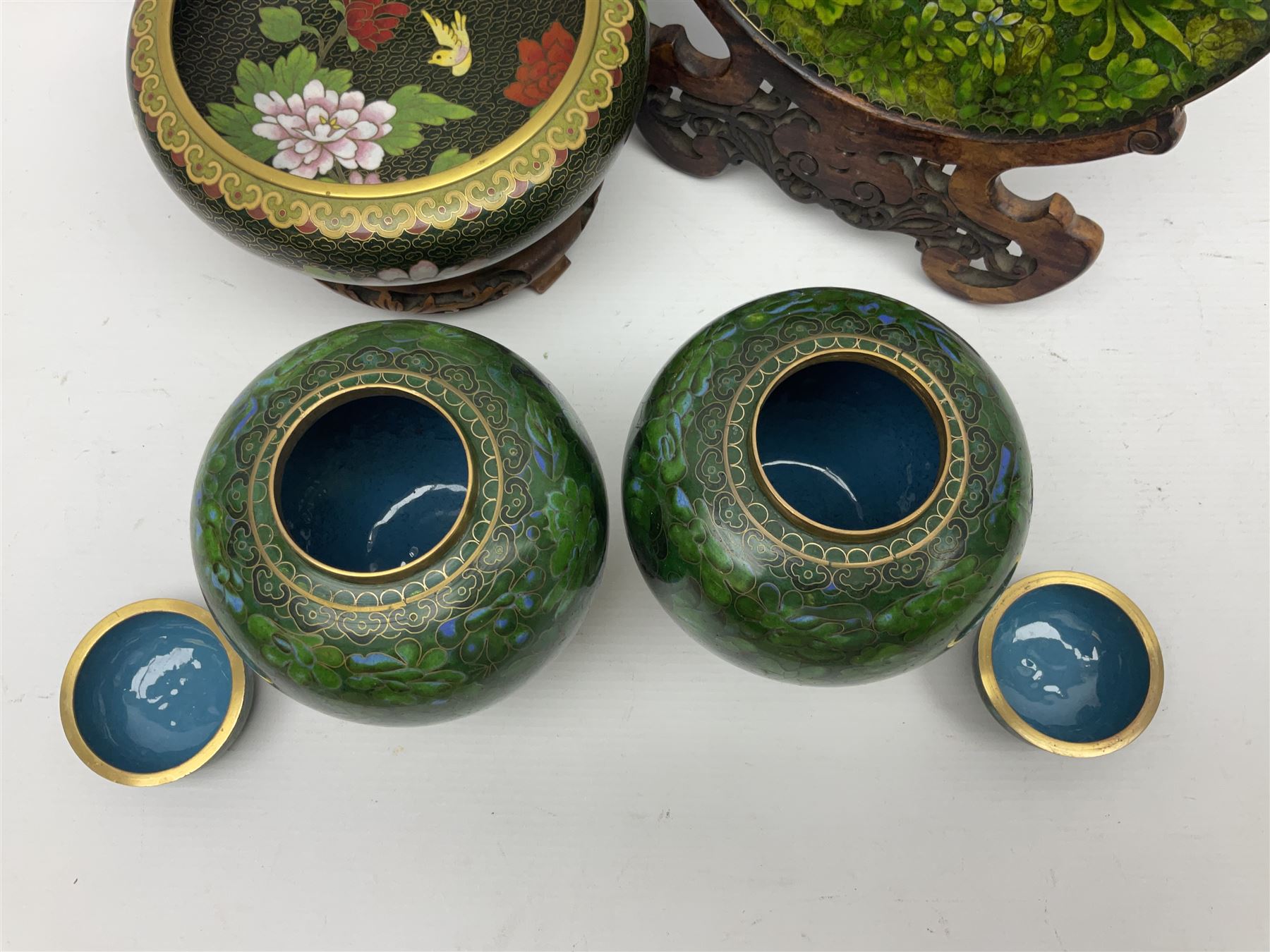Pair of modern cloisonne ginger jars having floral decoration with a green ground, with hardwood stands, together with a similar plate and a bowl decorated with birds and flowers  