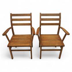 Treske of Thirsk - solid oak refectory dining suite, rectangular top with chamfered edge over trestle base united by a central stretcher, together with six matching slat back dining chairs, including two carvers, with panelled seats and square legs united by stretchers (H 87cm, W 62cm, D 57cm)
