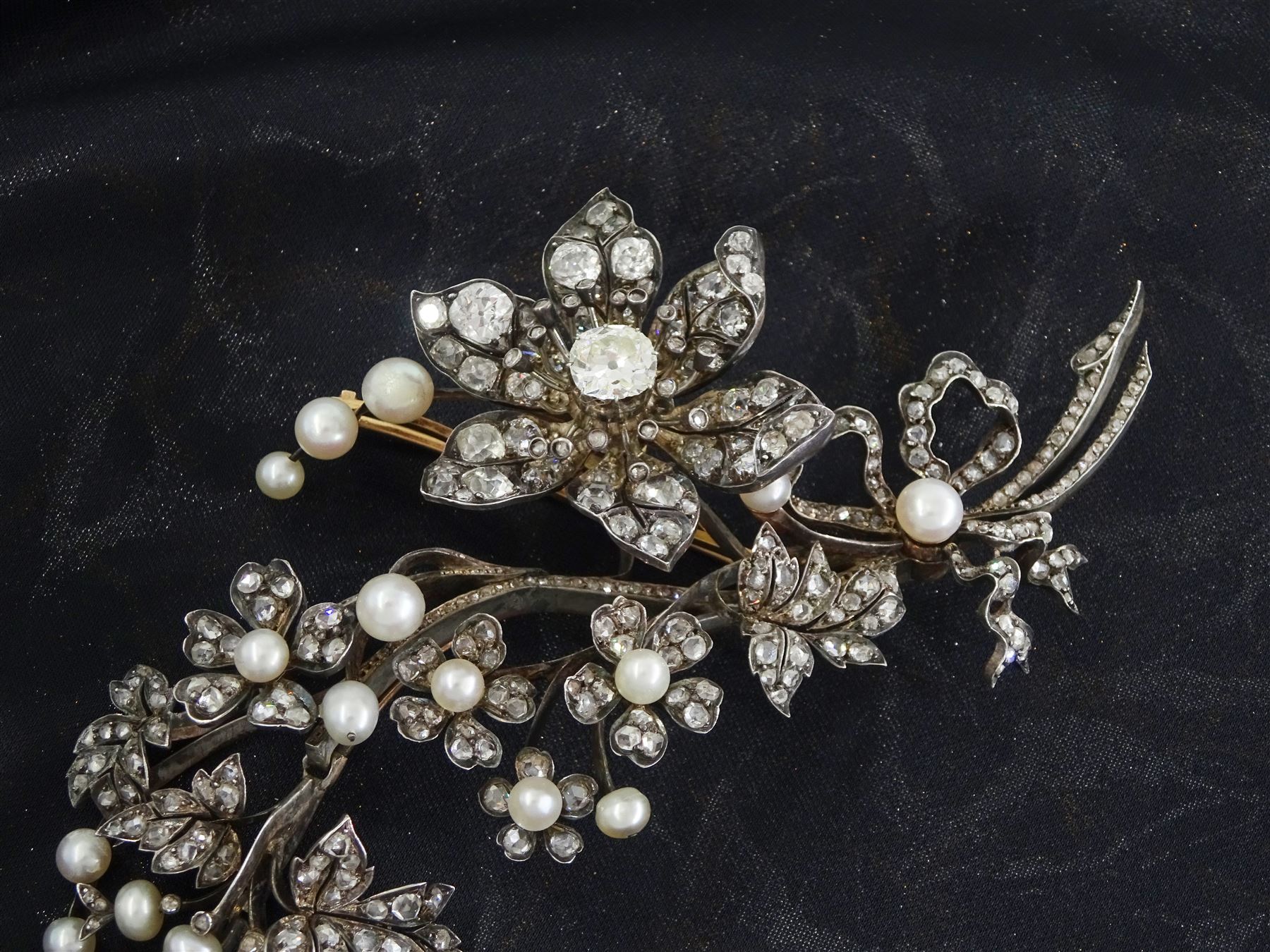 19th century gold and silver diamond and pearl en tremblant detachable brooch, the flower tremblant with a principal old cut diamond of approx 1.90 carat, the petals and stamen set with old cut and rose cut diamonds, total diamond weight approx 9.10 carat, to a foliate spray set set with further rose cut diamond and white / pink / cream pearls and ribbon tie