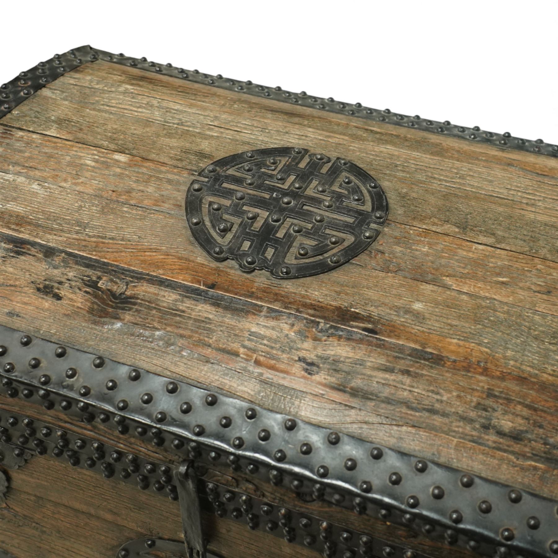 20th century Chinese camphorwood chest, the hinged lid opening to a plain interior, the exterior fitted with heavy iron strapwork, studded mounts and shaped corner plates, central circular lock escutcheon, with iron carrying handles