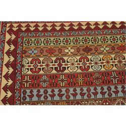 
Oman tribal design rug, field decorated with horizontal bands of stylised birds, flowerheads, stars and hooked geometric motifs in red, ivory, ochre and pale blue, enclosed by serrated ivory and red borders and narrow patterned guard stripes