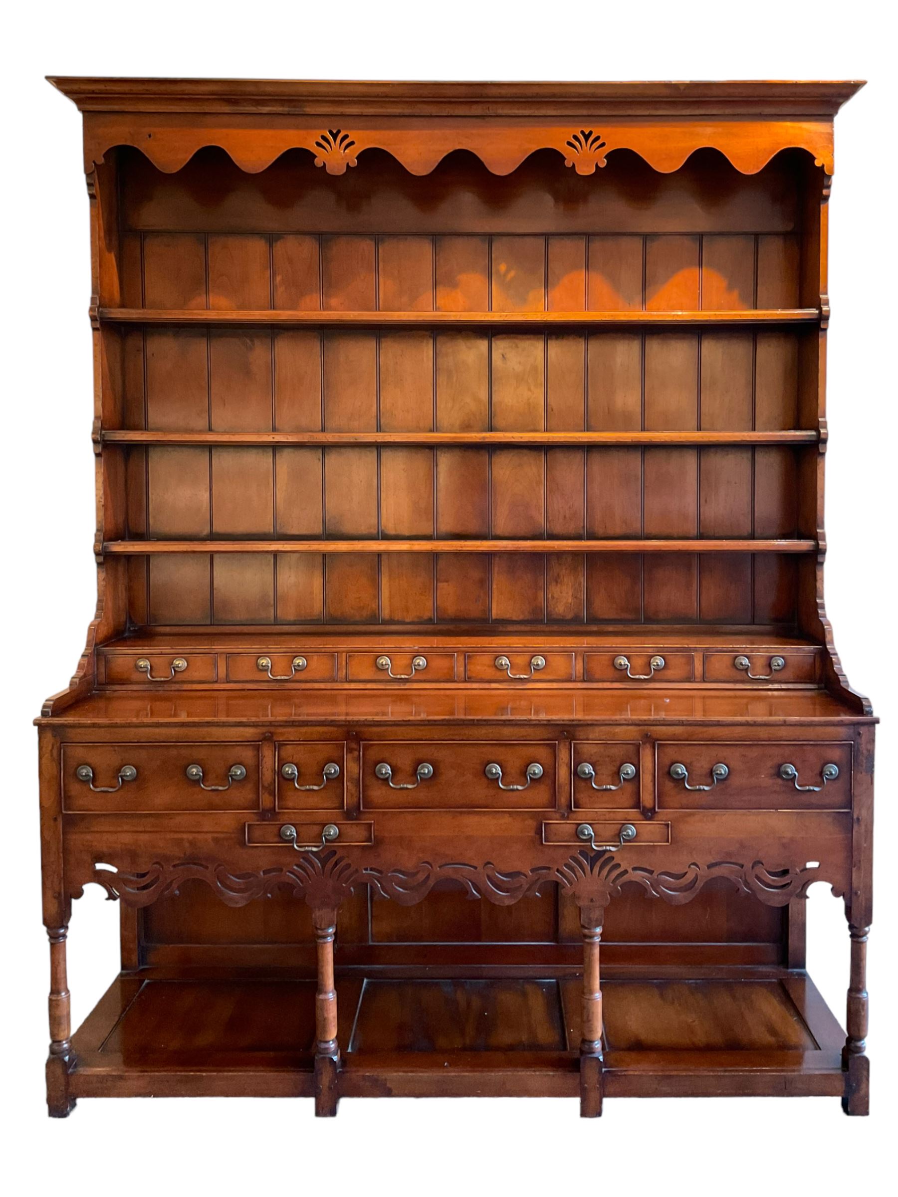 George III design cherry wood dresser, the projecting cornice over shaped frieze with pierced shell decoration, fitted with three shelves over six spice drawers, the base fitted with three long and two short drawers with cock-beaded facias, shaped and pierced apron over turned supports and panelled pot board base 