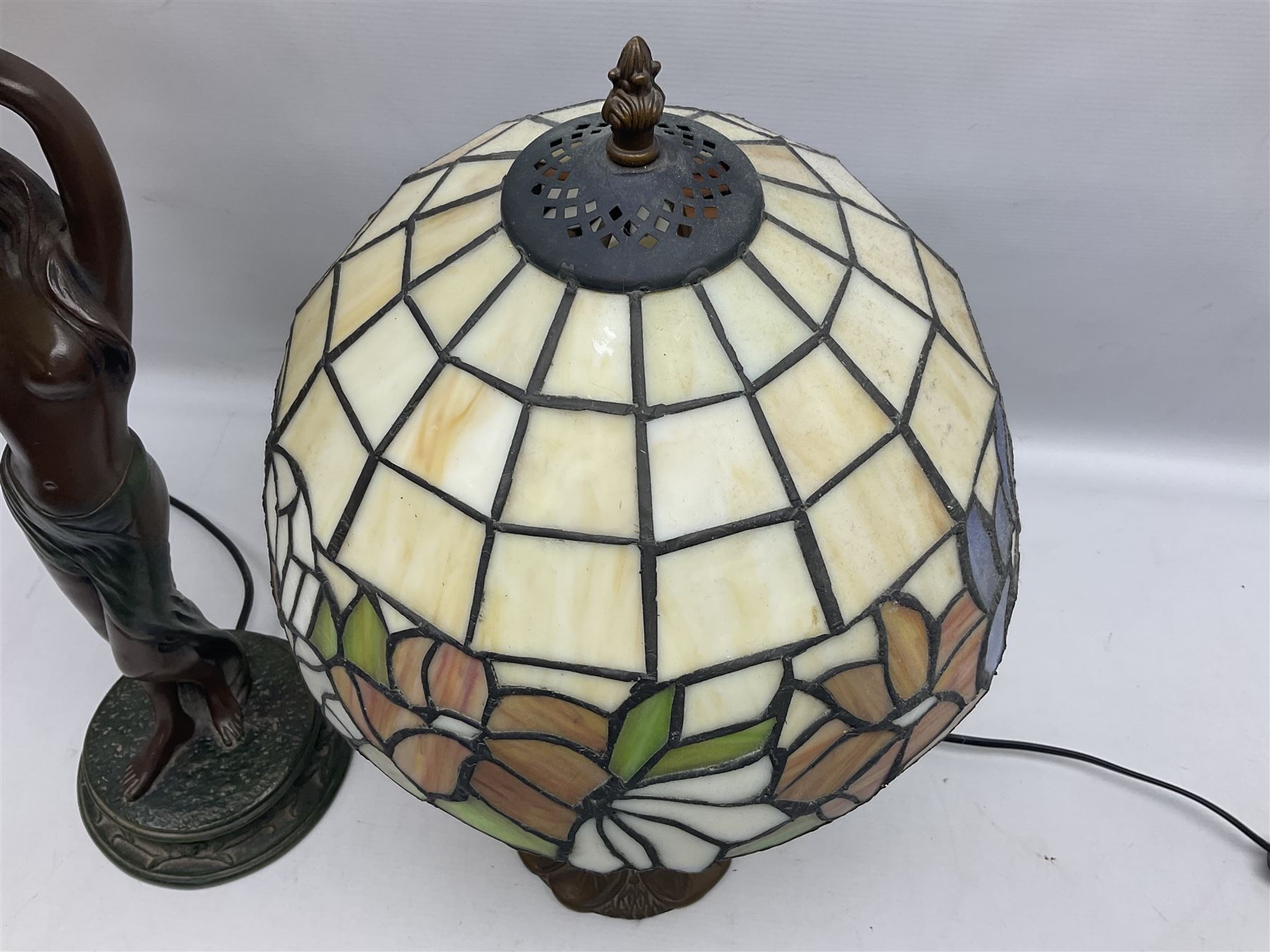 Tiffany style lamp in the form of a semi nude woman holding up a leaded lampshade together with a similar table lamp